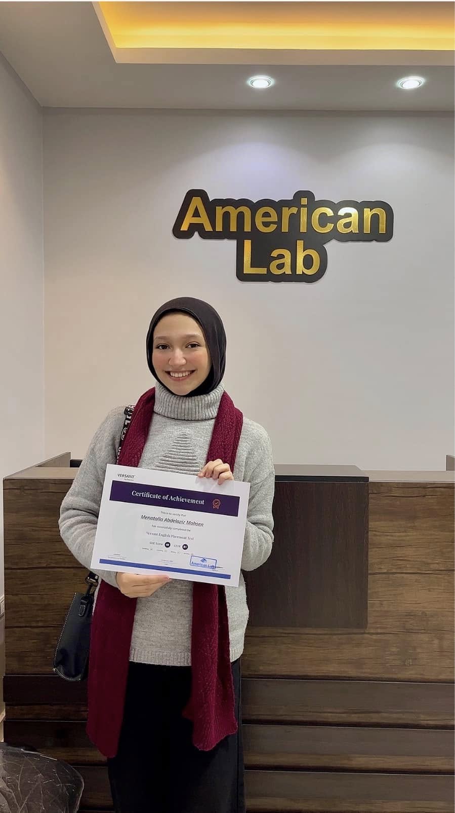 American Lab student holding a certificate inside the center