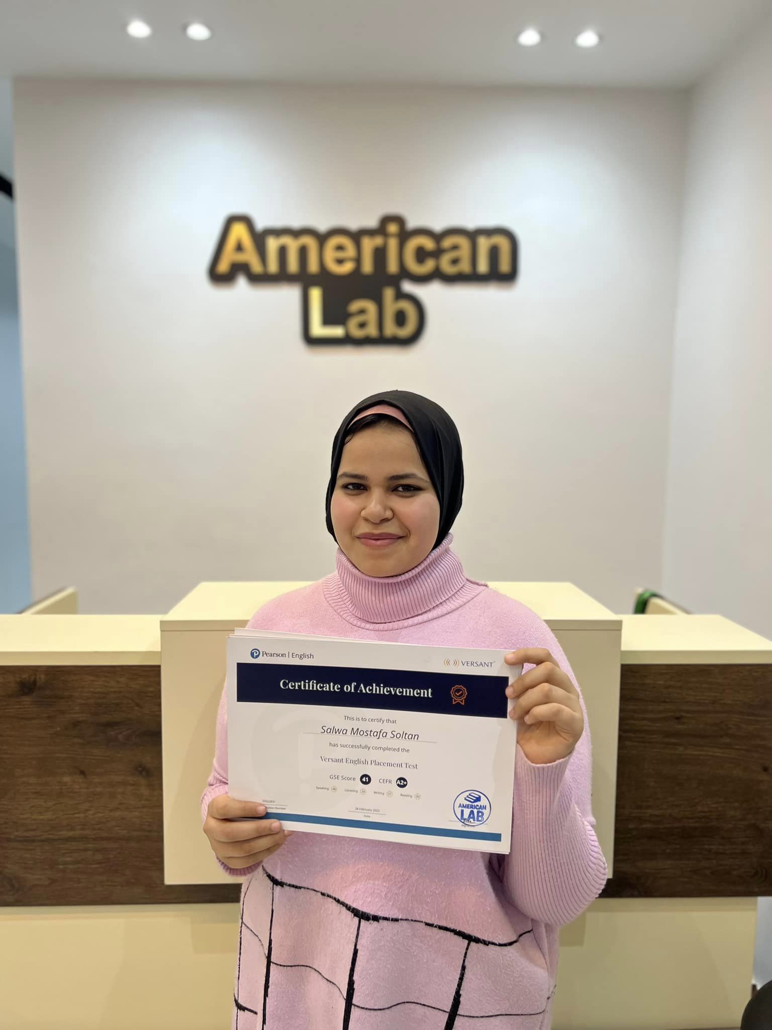 Student at American Lab holding a certificate